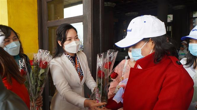 Bà Nguyễn Thị Hạnh, Phó Chủ tịch UBND tỉnh Quảng Ninh tặng hoa cho khách du lịch xông đất đầu năm mới. Ảnh: TTXVN phát Quảng Ninh đón đoàn khách xông đất đầu năm mới ảnh 1
