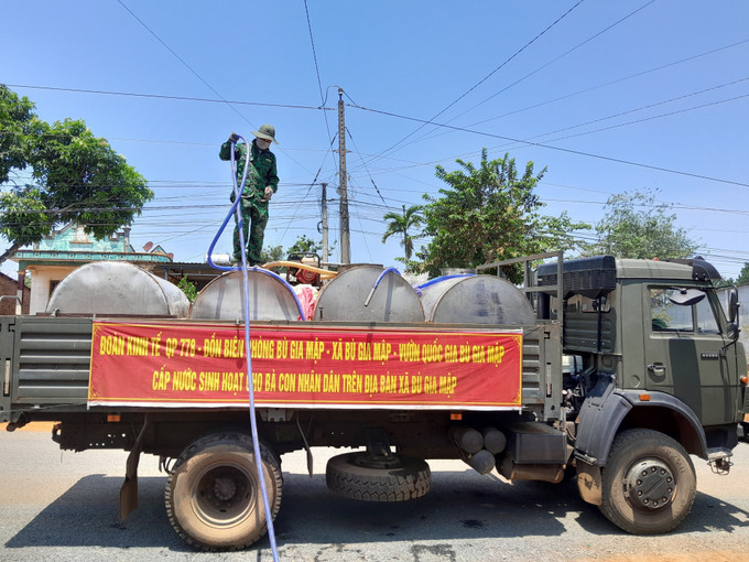 Xe bồn chở nước miễn phí về tới nhà các hộ dân thiếu nước sinh hoạt. Ảnh: K GỬIH – TTXVN BP1.jpg