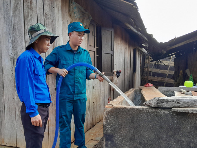 Lực lượng thanh niên xã Bù Gia Mập trực tiếp bơm nước vào bồn chứa cho người dân.Ảnh: K GỬIH – TTXVN BP2.jpg