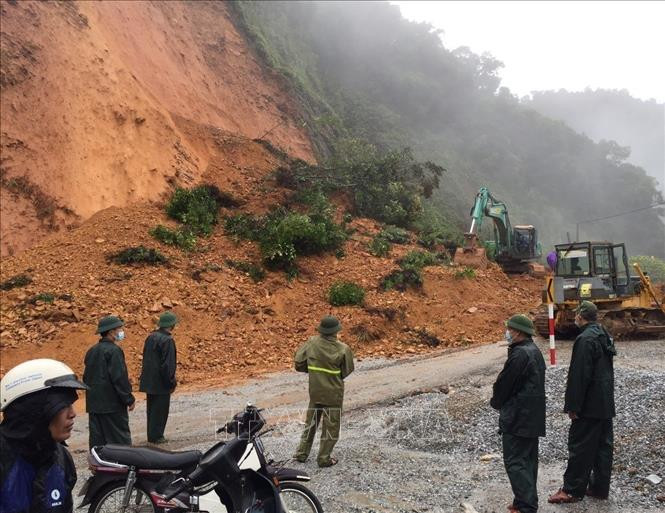 Các lực lượng chức năng huy động phương tiện máy móc sớm thông tuyến Quốc lộ 8A, đoạn qua Hương Sơn. Ảnh: TTXVN phát sat-lo-dat-14102021.jpg
