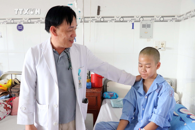 Bác sĩ Nguyễn Thanh Hải, Trưởng khoa Ngoại thần kinh - Bệnh viện Đa khoa tỉnh Ninh Thuận thăm hỏi bệnh nhân bị u màng não sau phẫu thuật thành công. Ảnh: Công Thử - TTXVN vna_potal_benh_vien_da_khoa_tinh_ninh_thuan_xu_ly_kip_thoi_va_dieu_tri_thanh_cong_nhieu_ca_benh_ve_nao_7242615 (1).jpg