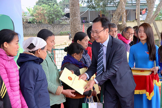 Đồng chí Lại Xuân Lâm, Phó Bí thư Thường thực Đảng ủy Khối các cơ quan Trung ương tặng quà cho các gia đình khó khăn xã Phong Phú. Ảnh: Thanh Hải - TTXVN HB2.jpg
