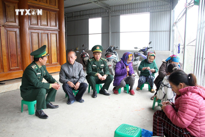 Già làng Lầu Gà Lồng (thứ 2, bên trái), bản Trường Sơn, xã Nậm Cắn (Kỳ Sơn, Nghệ An) cùng cán bộ chiến sỹ Đồn biên phòng Cửa khẩu Quốc tế Nậm Cắn tuyên truyền vận động người dân chấp hành quy định về xuất nhập cảnh. Ảnh: Văn Tý - TTXVN vna_potal_nhung_“tru_cot”_trong_cong_tac_tuyen_truyen_phat_trien_kinh_te_an_ninh_vung_bien_nghe_an_7397981.jpg