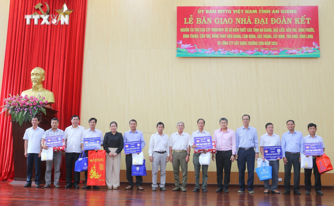 Đại diện các nhà tài trợ tặng biểu trưng tặng nhà "Đại đoàn kết" và quà cho các xã, thị trấn của huyện biên giới An Phú, tỉnh An Giang. Ảnh: Công Mạo-TTXVN vna_potal_an_giang_ban_giao_145_can_nha_dai_doan_ket_cho_ho_ngheo_kho_khan_ve_nha_o_7725978.jpg