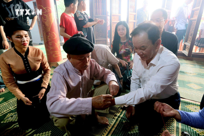 Buộc chỉ cổ tay để cầu may tại Nghi lễ “Tết Xíp xí” của người Thái trắng huyện Phù Yên. Ảnh: Quang Quyết – TTXVN vna_potal_chung_nhan_nghi_le_“tet_xip_xi”_la_di_san_van_hoa_phi_vat_the_quoc_gia_7541734.jpg