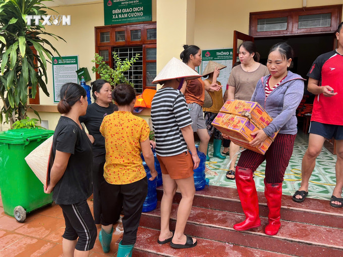 Người dân đến nhận hàng cứu trợ tại điểm tập kết của huyện Chợ Đồn. Ảnh: TTXVN phát vna_potal_bac_kan_no_luc_ho_tro_cac_ho_dan_bi_ngap_lut_7591121.jpg