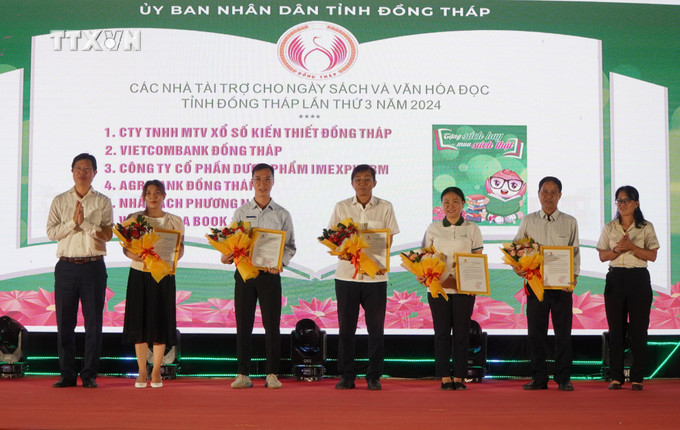 Lãnh đạo tỉnh Đồng Tháp tặng hoa và thư cảm ơn những đơn vị tặng tủ sách khuyến học năm 2024. Ảnh: Nhựt An - TTXVN vna_potal_khai_mac_ngay_sach_va_van_hoa_doc_lan_thu_iii_tai_dong_thap_7332776 (1).jpg