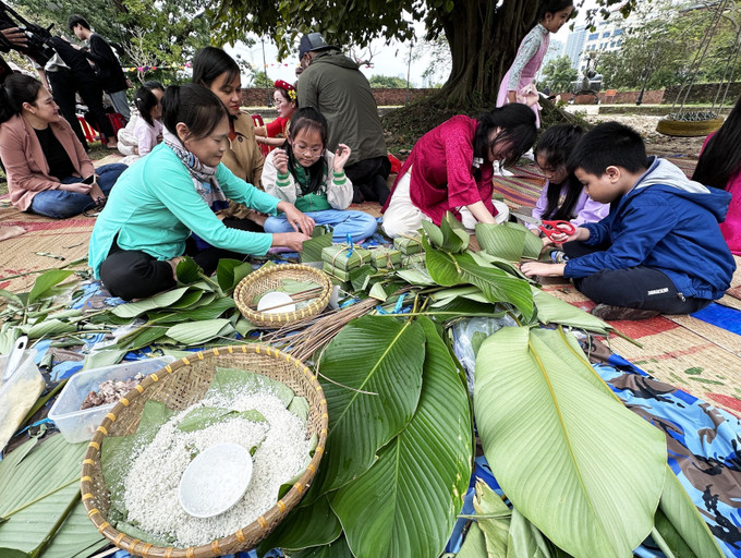 Khách tham gia trải nghiệm gói bánh chưng tại Phiên chợ. Ảnh: Trần Lê Lâm – TTXVN DN3.jpg