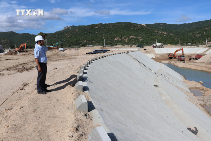 Đại diện chủ đầu tư kiểm tra tiến độ thi công nâng cấp ao Bầu Tró giữa ở xã Vĩnh Hải (huyện Ninh Hải, Ninh Thuận). Ảnh: Nguyễn Thành - TTXVN vna_potal_ninh_thuan_dau_tu_xay_dung_ha_tang_vung_dung_du_an_hai_nha_may_dien_hat_nhan_7651528 (1).jpg