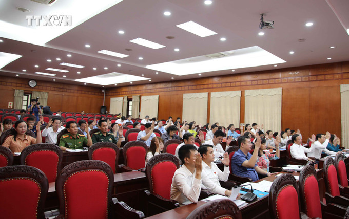 Các đại biểu biểu quyết thông qua nghị quyết kỳ họp. Ảnh: Nguyễn Cường - TTXVN. vna_potal_son_la_to_chuc_ky_hop_chuyen_de_thu_21_hdnd_tinh_khoa_xv_7431358.jpg