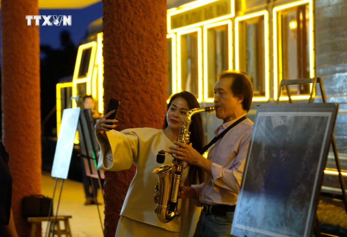 Du khách thích thú với màn trình diễn saxophone tại sân ga Đà Lạt trước giờ tàu hỏa khởi hành. Ảnh: Nguyễn Dũng – TTXVN vna_potal_ra_mat_san_pham_du_lich_da_lat_dem_say_tren_tuyen_duong_sat_co_7412909.jpg