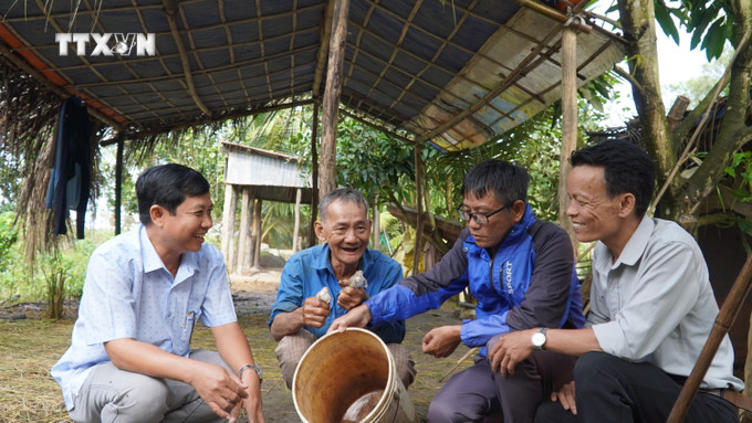 Phó Chủ tịch UBND xã Vĩnh Phú, huyện Giang Thành tham quan mô hình nuôi ếch thịt để thoát nghèo hộ ông Đặng Thanh Tùng. Ảnh: Văn Sĩ - TTXVN vna_potal_huyen_bien_gioi_giang_thanh_kien_giang_no_luc_giam_ngheo_ben_vung_7618014.jpg