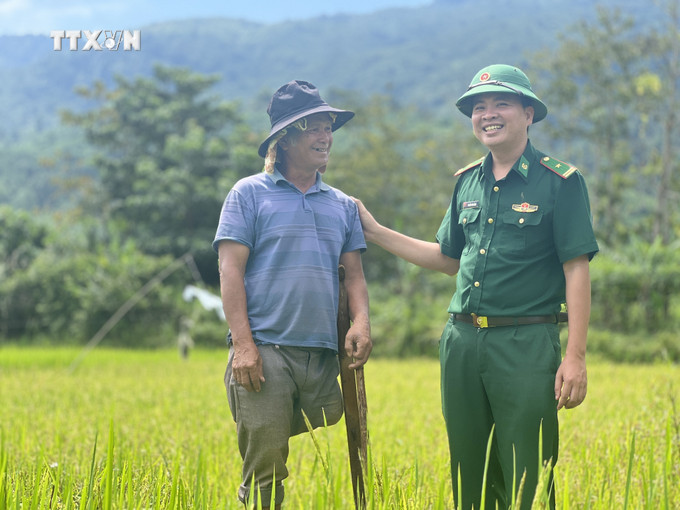 Thiếu tá Nguyễn Văn Bằng hỗ trợ gia đình ông Hồ Bồng ở thôn Cheng (xã Hướng Phùng) trồng lúa năng suất cao, xóa đói giảm nghèo. Ảnh: Nguyên Linh-TTXVN vna_potal_nguoi_linh_bien_phong_quang_tri_mang_mua_vang_no_am_den_dan_ban_7647715.jpg