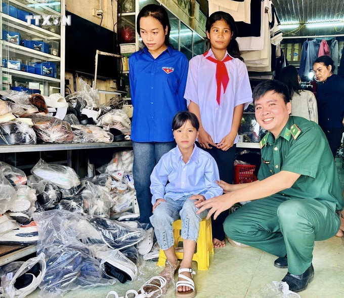 Thiếu tá Nguyễn Văn Bằng tích cực giúp đỡ học sinh ở xã Hướng Phùng có điều kiện đến trường. Ảnh: Nguyên Linh-TTXVN vna_potal_nguoi_linh_bien_phong_quang_tri_mang_mua_vang_no_am_den_dan_ban_7647712.jpg
