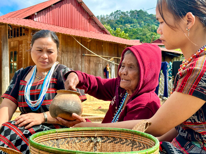 Cụ Bhling Truốh (ở giữa) truyền dạy cách làm gốm cổ cho cháu con trong làng. Ảnh: Khánh Nguyên Anh gom 8.jpg
