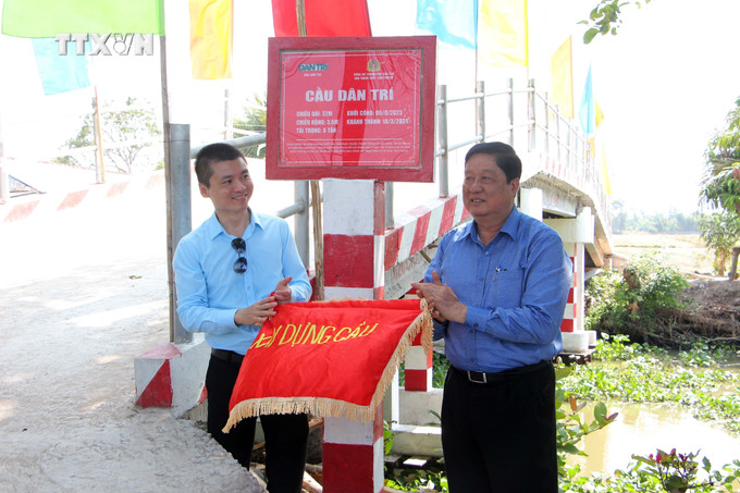 Phó Bí thư thường trực Thành ủy Cần Thơ Phạm Văn Hiểu (phải) và Tổng Biên tập báo Dân trí Phạm Tuấn Anh gỡ biển công trình cầu Dân trí. Ảnh: Trung Kiên - TTXVN vna_potal_can_tho_khanh_thanh_cau_nong_thon_ket_noi_ap_bi_co_lap_7276987.jpg