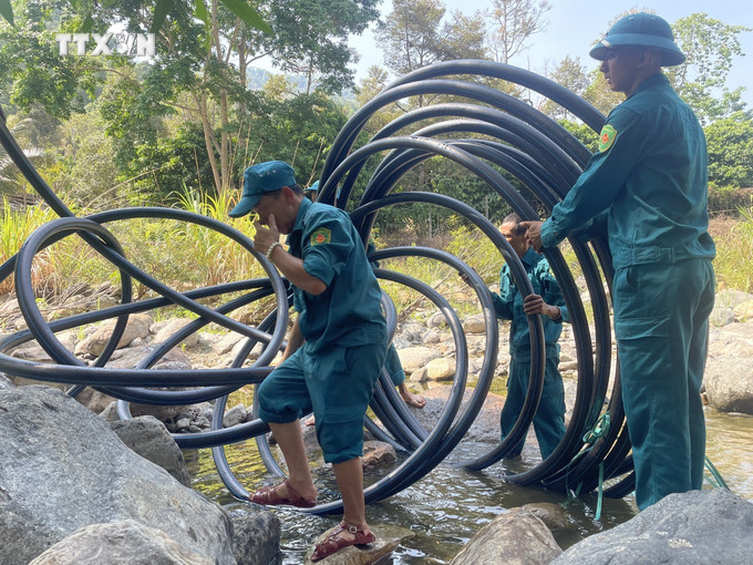 Lực lượng chức năng kéo ống dẫn lên thượng nguồn suối Đam Re (nguồn cấp nước chính cho Trạm cấp nước Đạ M’ri) để dẫn nước về trạm. Ảnh: TTXVN phát vna_potal_tram_cap_nuoc_da_m’ri_lam_dong_hoat_dong_tro_lai_nguoi_dan_da_co_nuoc_sinh_hoat_7331293.jpg