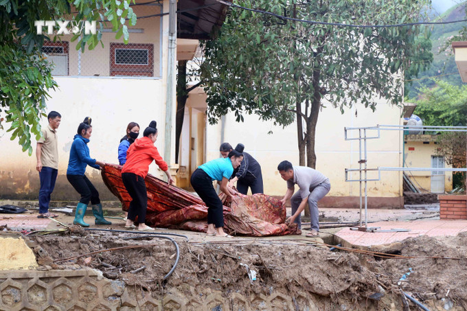 Giáo viên Trường Tiểu học xã Chiềng Nơi khẩn trương khắc phục hậu quả của mưa lũ. Ảnh: Quang Quyết – TTXVN vna_potal_tich_cuc_trien_khai_cong_tac_khac_phuc_hau_qua_mua_lu_tai_son_la_7545919.jpg