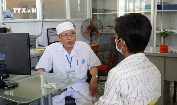 Bác sĩ CKI Bùi Văn Bời, Phó Trưởng Khoa Truyền nhiễm, Trung tâm Y tế huyện Giồng Riềng (Kiên Giang) khám bệnh cho người nhiễm HIV. Ảnh: Văn Sĩ-TTXVN vna_potal_nhung_bac_si_dieu_duong_gioi_ve_chuyen_mon_va_y_duc_o_kien_giang_7240605.jpg