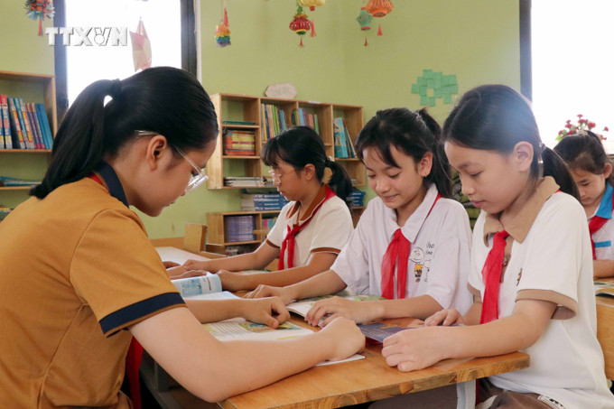 Học sinh Trường tiểu học Tứ Quận, huyện Yên Sơn, đọc sách tại Thư viện Cầu vồng. Ảnh: Quang Cường – TTXVN vna_potal_tuyen_quang_lan_toa_van_hoa_doc_trong_nha_truong_7326453.jpg