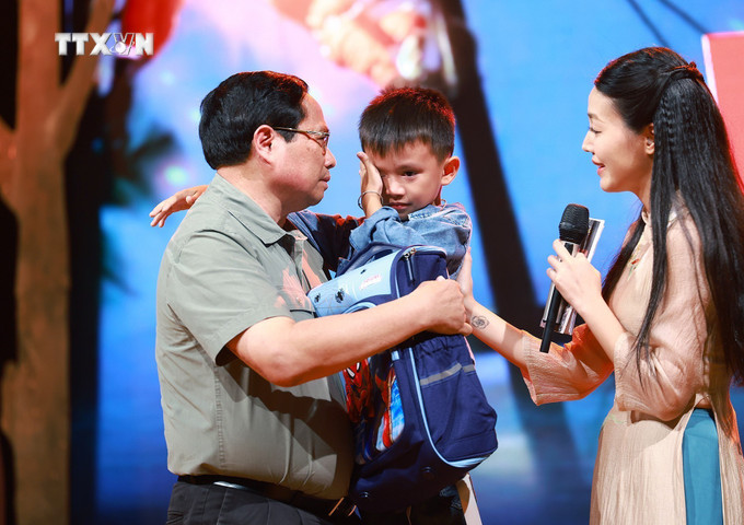 Thủ tướng Phạm Minh Chính động viên cháu Nguyễn Quốc Bảo (sinh năm 2016) bị mất cả bố và chị gái khi 3 người bị nước lũ cuốn trôi trong lúc di chuyển bằng xe máy qua cầu tràn thôn Cầu Treo, xã Yên Thuận, huyện Hàm Yên, tỉnh Tuyên Quang. Ảnh: Dương Giang-TTXVN vna_potal_thu_tuong_pham_minh_chinh_du_chuong_trinh_diem_tua_viet_nam_7597506.jpg