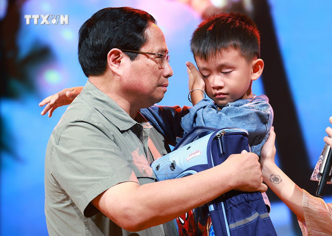 Thủ tướng Phạm Minh Chính động viên cháu Nguyễn Quốc Bảo (sinh năm 2016) bị mất cả bố và chị gái khi 3 người bị nước lũ cuốn trôi trong lúc di chuyển bằng xe máy qua cầu tràn thôn Cầu Treo, xã Yên Thuận, huyện Hàm Yên, tỉnh Tuyên Quang. Ảnh: Dương Giang-TTXVN vna_potal_thu_tuong_pham_minh_chinh_du_chuong_trinh_diem_tua_viet_nam_7597519.jpg