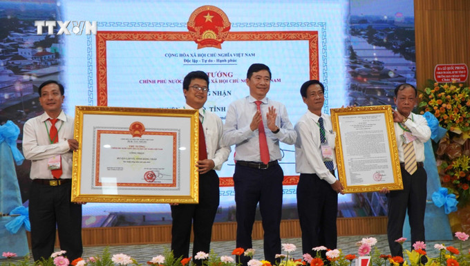 Thừa ủy quyền Thủ tướng Chính phủ, Chủ tịch UBND tỉnh Đồng Tháp Phạm Thiện Nghĩa trao Quyết định và Bằng công nhận huyện Lấp Vò đạt chuẩn nông thôn mới. Ảnh: Nhựt An - TTXVN vna_potal_huyen_lap_vo_dong_thap_dat_chuan_nong_thon_moi_7587651.jpg