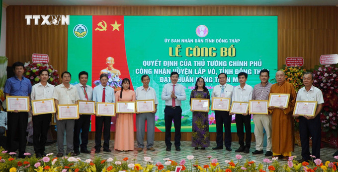 Khen thưởng các cá nhân có thành tích xuất sắc trong xây dựng nông thôn mới của huyện Lấp Vò. Ảnh: Nhựt An - TTXVN vna_potal_huyen_lap_vo_dong_thap_dat_chuan_nong_thon_moi_7587642 (1).jpg