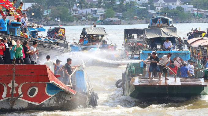 Phun nước giữa các tàu để cầu mong may mắn cho năm mới. Ảnh: Ánh Tuyết - TTXVN cantho4.jpg