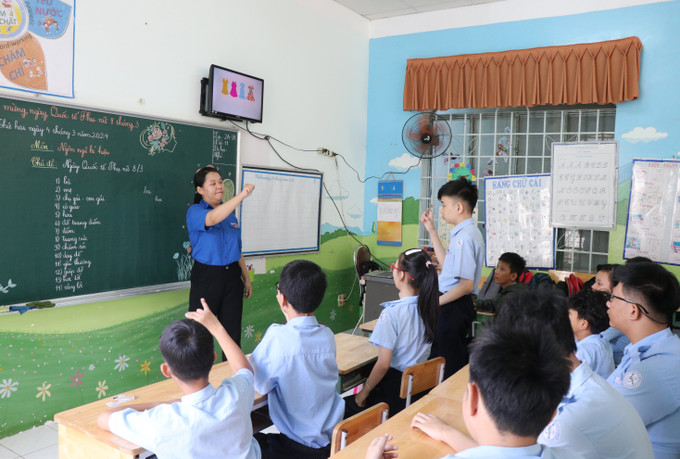Một giờ học của học sinh khuyết tật khiếm thính khối 2-3, cô giáo hướng dẫn học sinh diễn đạt từ ngữ bằng ngôn ngữ ký hiệu. Ảnh: Phan Sáu – TTXVN lophoc2.jpg