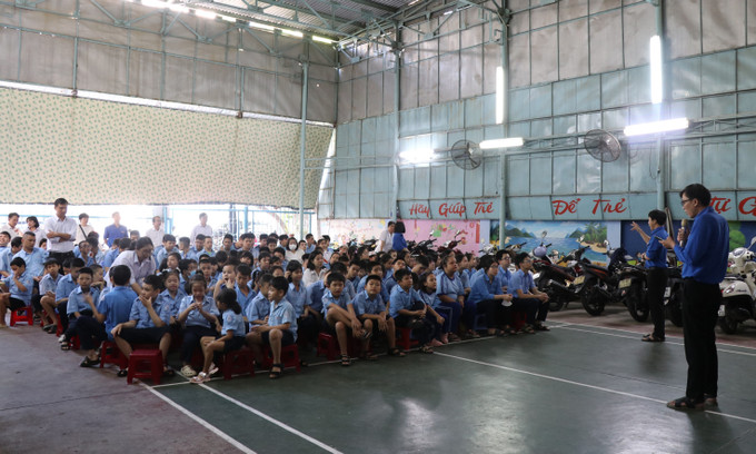 Trong giờ chào cờ, thầy giáo chia sẻ chủ điểm của tuần bằng lời cùng với một thầy giáo diễn đạt bằng ngôn ngữ ký hiệu, đảm bảo toàn bộ học sinh khuyết tật khiếm thính và trí tuệ đều nghe, nhìn thấy hiểu nội dung. Ảnh: Phan Sáu – TTXVN lophoc3.jpg