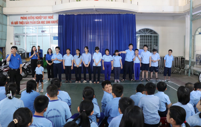 Khen ngợi, động viên học sinh khuyết tật bằng cách tuyên dương các em trước toàn thể giáo viên, học sinh của Trung tâm vào giờ chào cờ đầu tuần. Ảnh: Phan Sáu – TTXVN lophoc4.jpg