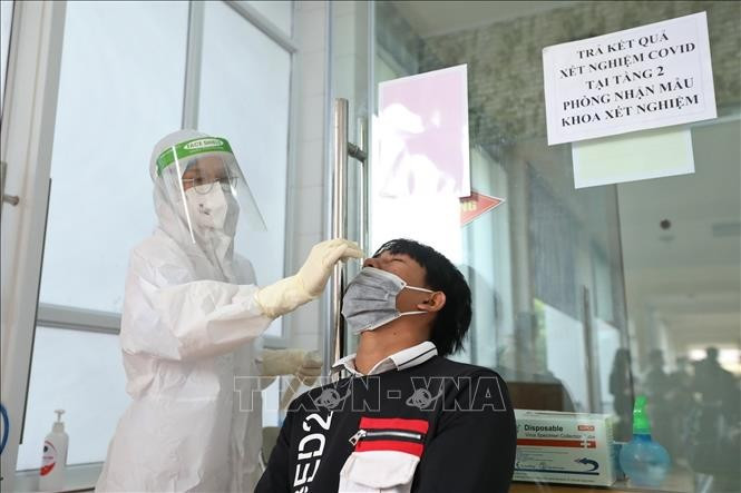 Nhân viên y tế lấy mẫu xét nghiệm COVID-19 cho người dân tại bệnh viện Đa khoa khu vực Nghĩa Lộ (Yên Bái). Ảnh tư liệu minh họa: Minh Quyết/ TTXVN yb-1.jpg