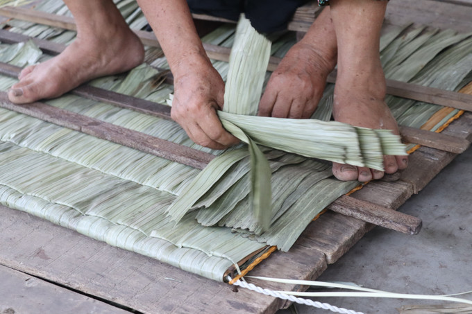 Đôi tay khéo léo của những người nông dân Yên Lạc chằm nên những chiếc áo tơi che nắng. ao-toi3.jpg