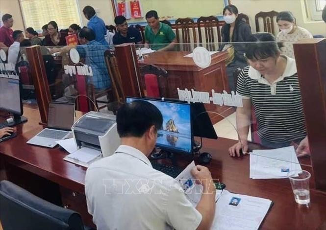 Cán bộ Trung tâm Phục vụ hành chính công xã Lạc Lương giải quyết hồ sơ thủ tục hành chính cho người dân. Ảnh: Vũ Hà/TTXVN lac-luong-pt1.jpg