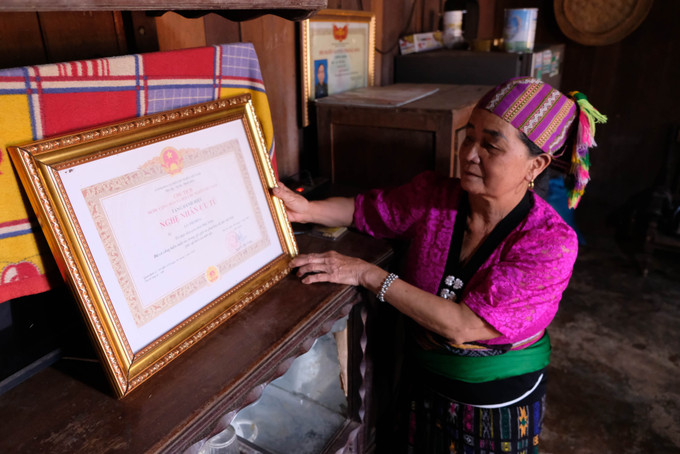 Nghệ nhân Lò Thị Hoa (dân tộc Thái, 69 tuổi, thôn Trung Sơn, xã Đắk Wil, Lâm Đồng) cùng danh hiệu “Nghệ nhân ưu tú” được Nhà nước phong tặng năm 2019. Ảnh: Nguyễn Dũng – TTXVN nghe-nhan-ld1.jpg