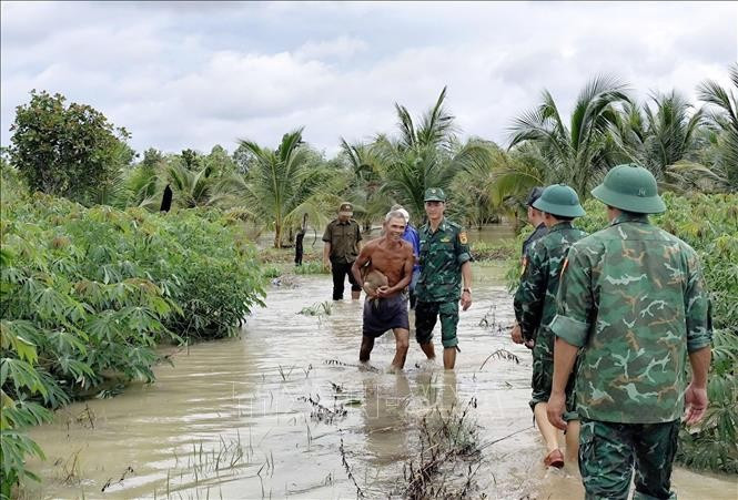 CCán bộ, chiến sĩ Đồn Biên phòng Ia Rvê cùng các lực lượng chức năng tuyên truyền, hướng dẫn người dân đến nơi an toàn. Ảnh: TTXVN phát. dak-lak-ung-pho1.jpg