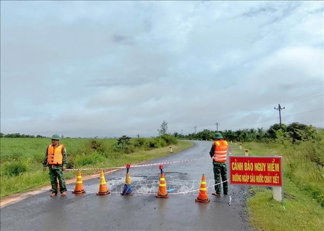 Lực lượng chức năng tại tỉnh Đắk Lắk lập chốt chặn cảnh báo, hướng dẫn nhân dân không di chuyển qua khu vực ngập sâu, nguy hiểm. Ảnh: TTXVN phát. dak-lak-ung-pho5.jpg