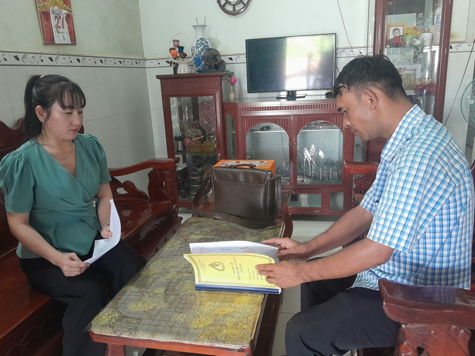 Tổ trưởng Tổ Tiết kiệm & Vay vốn hướng dẫn quy định vay vốn cho hộ gia đình bà Lê Thị Hường ở thôn Sơn Trung, xã Phú Nghĩa. Ảnh: K GỬIH/ TTXVN tin-dung-sv1.jpg