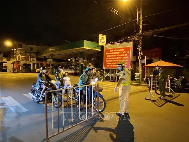Lực lượng cảnh sát giao thông yêu cầu người dân dừng xe khai báo y tế trên đường Lê Quang Định (phường 1, quận Gò Vấp, Tp. Hồ Chí Minh). Ảnh: Hồng Giang - TTXVN.