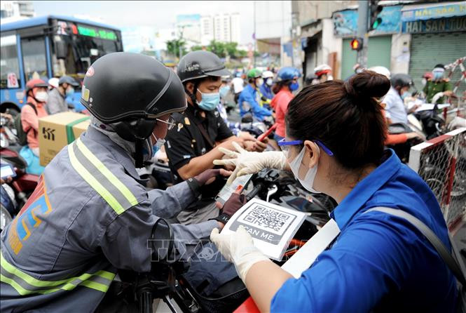 Người dân khai báo y tế để vào Quận Gò Vấp trong những ngày đầu thực hiện giãn cách xã hội. Do chưa thống nhất cách quản lý nên đã xảy ra tình trạng ùn tắc tại các điểm kiểm soát. Ảnh: An Hiếu- TTXVN