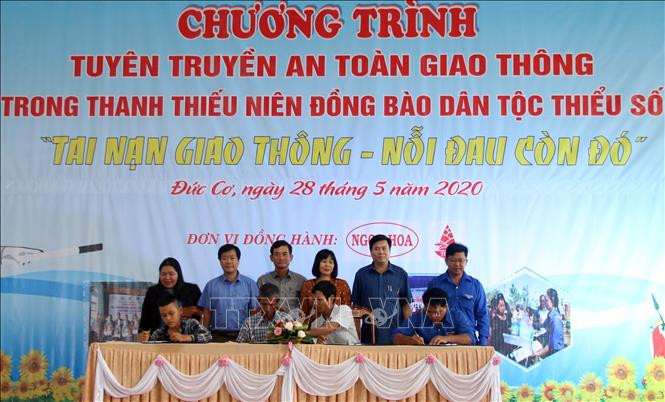 Đại diện Già làng, đoàn thanh niên, chính quyền địa phương ký cam kết tuyên truyền và thực hiện an toàn giao thông. Ảnh: Hồng Điệp - TTXVN