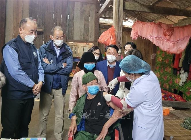 Giám đốc WHO khu vực Tây Thái Bình Dương và đoàn công tác quan sát hoạt động tiêm chủng vaccine phòng COVID-19 tại nhà cho người già yếu không đến được các cơ sở y tế, tại thôn Đá Đứng, xã Đại Sơn. Ảnh: TTXVN