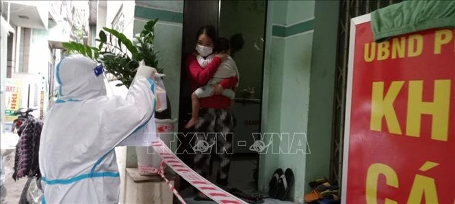 Nhân viện Trạm y tế lưu động phường Hải Cảng (TP Quy Nhơn) đến thăm khám cho bệnh nhân F0 đang điều trị tại nhà. Ảnh:TTXVN