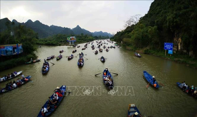Dòng thuyền chở du khách tấp nập trên dòng suối Yến. Ảnh: Thanh Tùng-TTXVN