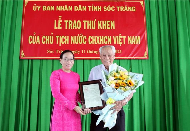 Phó Chủ tịch UBND tỉnh Sóc Trăng Huỳnh Thị Diễm Ngọc trao thư khen của Chủ tịch nước cho cụ Trần Cang. Ảnh: Trung Hiếu-TTXVN