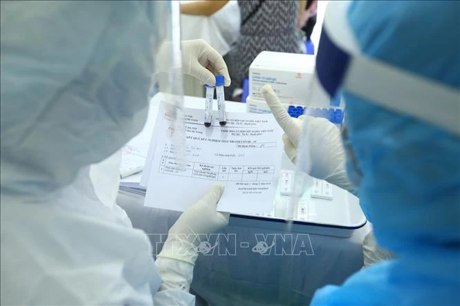 Nhân viên y tế lấy mẫu xét nghiệm nhanh cho người về từ Đà Nẵng, tại phường Bách Khoa và phường Cầu Dền (quận Hai Bà Trưng) sáng 01/8/2020. Ảnh: Minh Quyết - TTXVN
