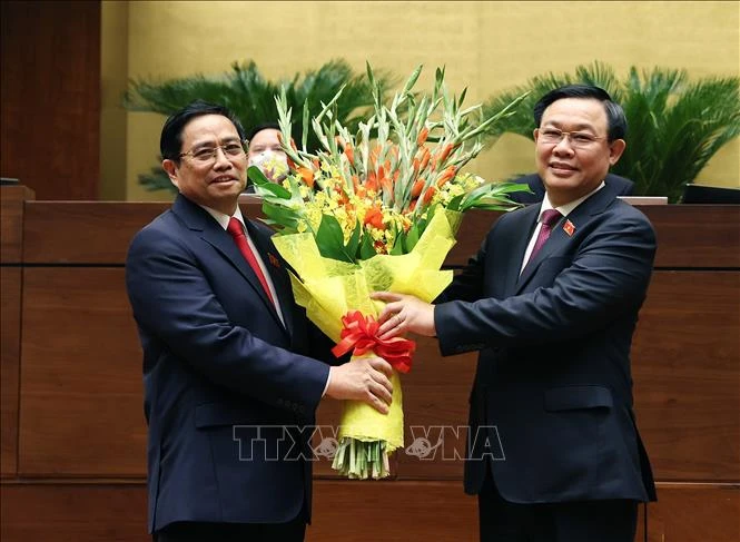 Chủ tịch Quốc hội Vương Đình Huệ tặng hoa chúc mừng Thủ tướng Phạm Minh Chính. Ảnh: Dương Giang - TTXVN