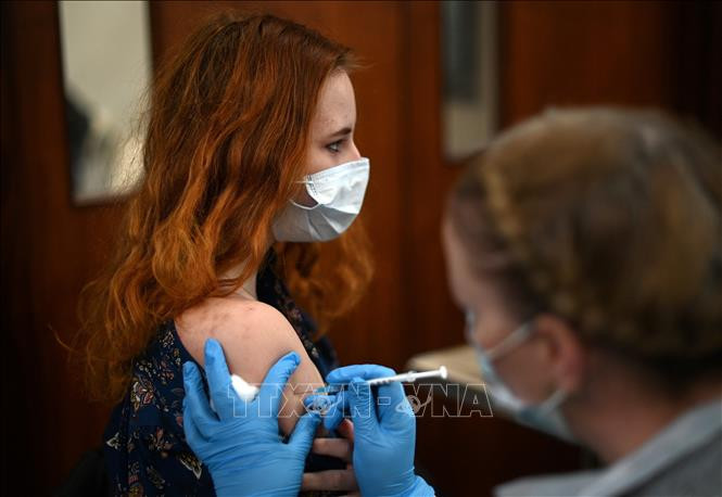 Nhân viên y tế tiêm vaccine phòng COVID-19 cho người dân tại London, Anh, ngày 4/12/2021. Ảnh: AFP/ TTXVN