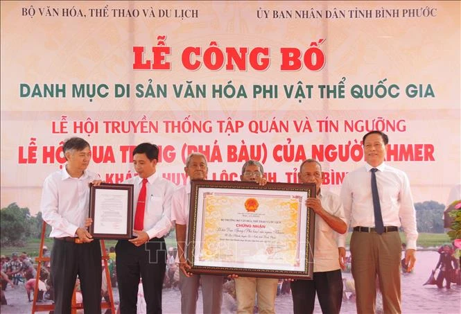 Đại diện địa phương nhận quyết định công nhận Lễ hội Phá Bàu là di sản văn hóa phí vật thể. Ảnh: K GỬIH –TTXVN